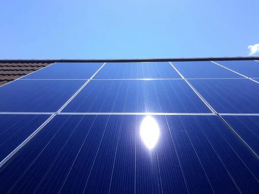 Pristine solar panels reflecting sunlight on a UK home roof